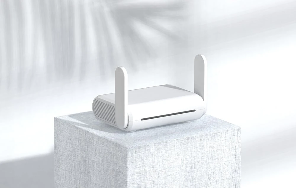 Un router alb cu antene pe un suport gri, pe un fundal de culoare deschisă
