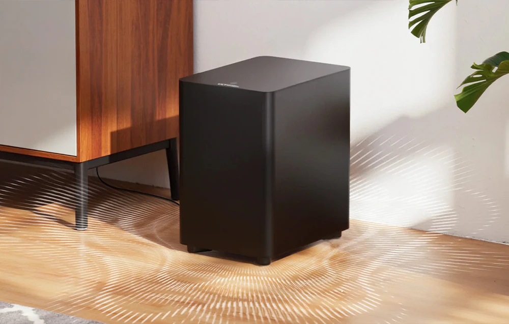 Subwoofer așezat pe o podea din lemn, cu unde sonore albe în jurul său