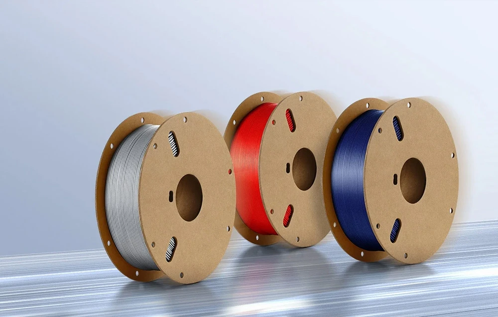 Trei role de filament Anycubic în culorile alb, roșu și albastru.