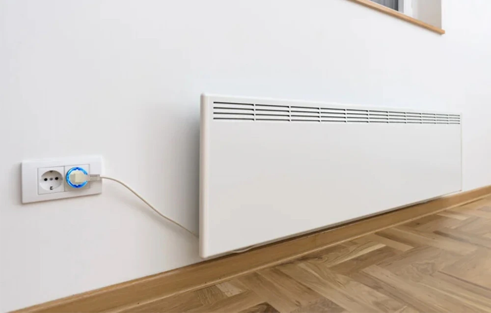 Shelly Plug S cu lumină albastră conectat la un încălzitor electric pe un perete alb