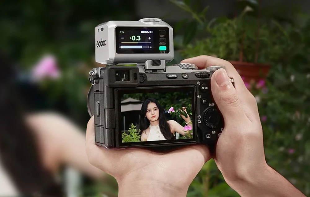 Un mini-blitz Godox iT30Pro S argintiu montat pe un aparat foto în timpul realizării unei fotografii