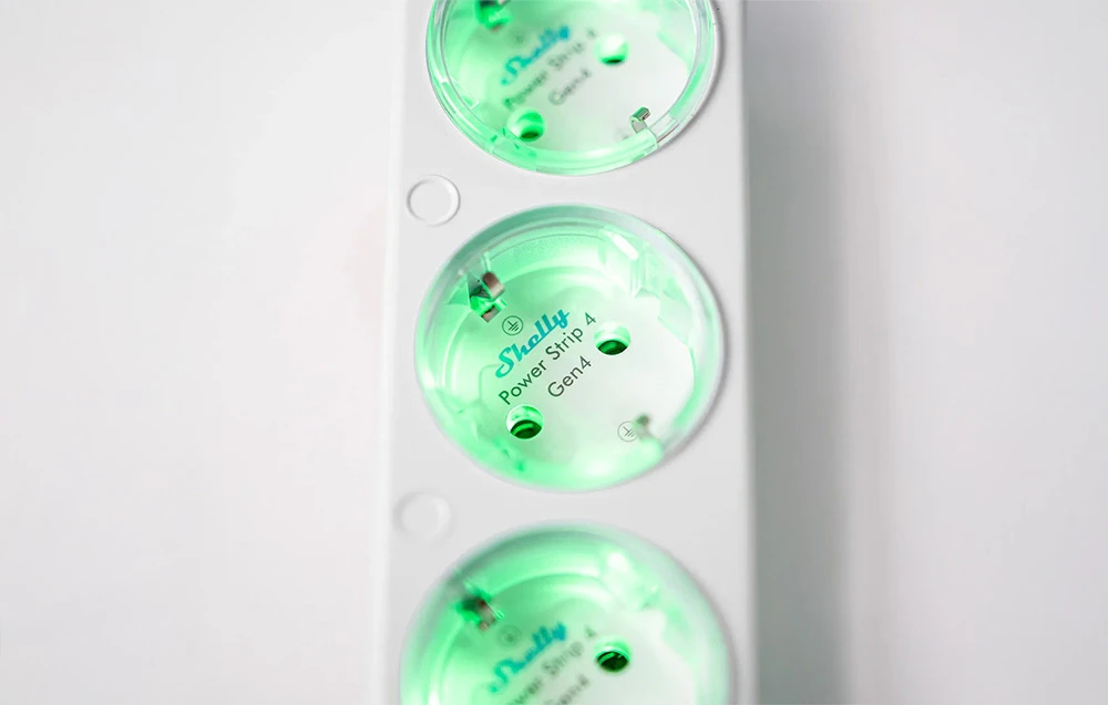Prim plan al unui prelungitor alb Shelly Power Strip 4 cu prize marcate cu verde și etichetate Gen4