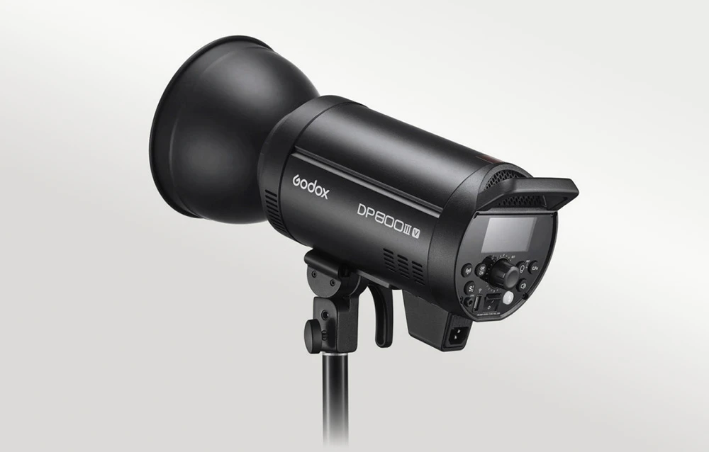 Blițul de studio Godox DP800III-V cu o cupolă de modelare neagră atașată, montat pe un trepied negru de iluminat