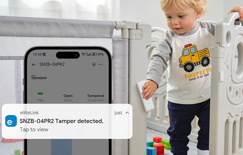 Un băiețel care se cațără din pătuț, lângă un smartphone cu notificările activate