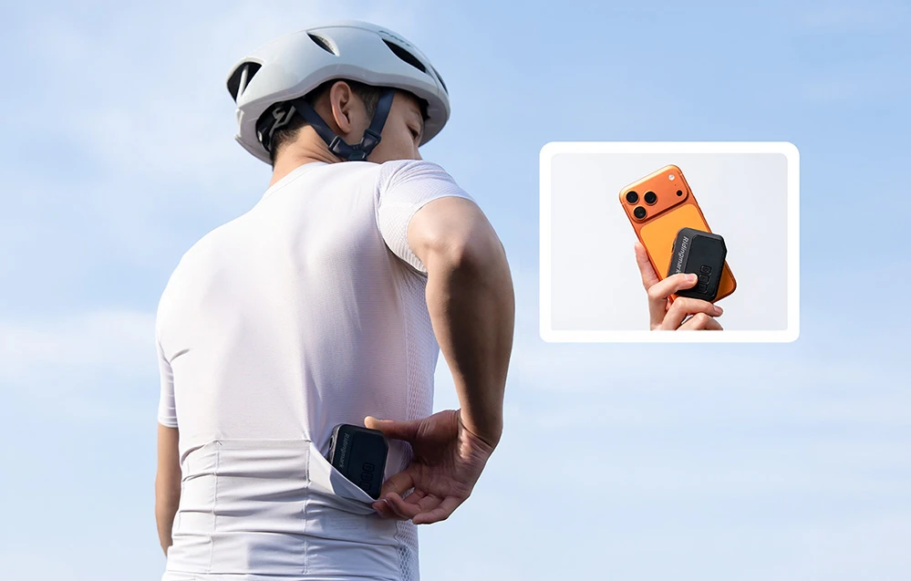 Un ciclist care își pune pompa pentru bicicletă AS280PRO în buzunarul tricoului și îi compară dimensiunea cu cea a unui telefon