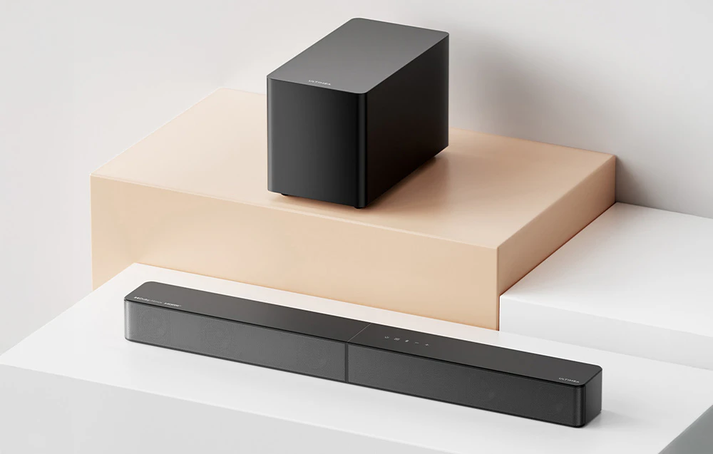 Subwoofer și bară de sunet Ultimea prezentate pe platforme geometrice într-un studio luminos