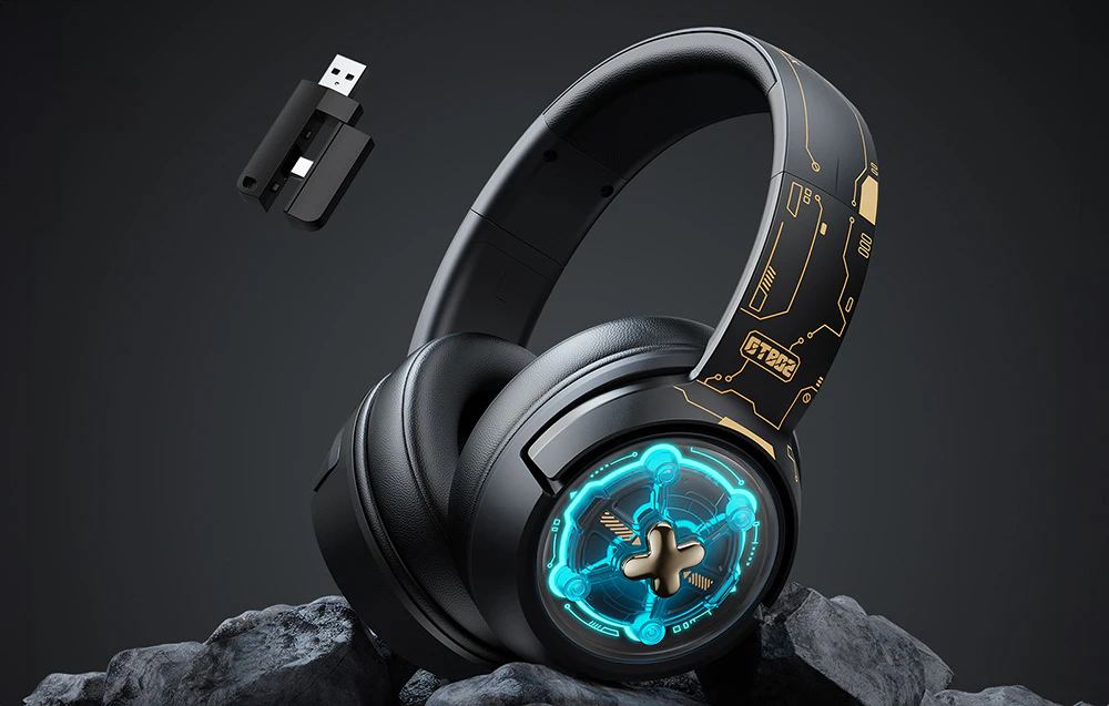 Căști de gaming negre așezate pe pietre, cu un adaptor USB plutind în apropiere