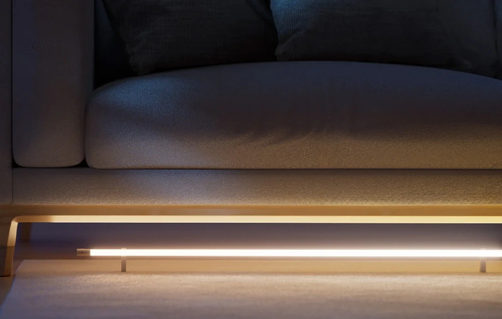 Bandă LED sub canapea care iluminează podeaua cu lumină galbenă caldă - iluminat decorativ