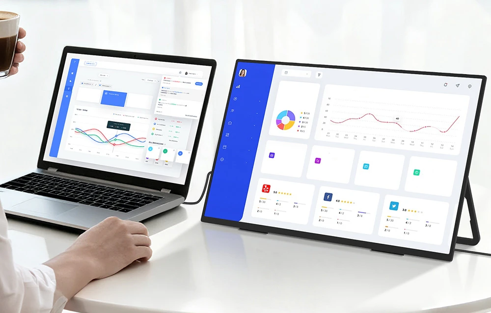 Laptop conectat la un monitor portabil, ambele dispozitive afișând grafice avansate și date analitice