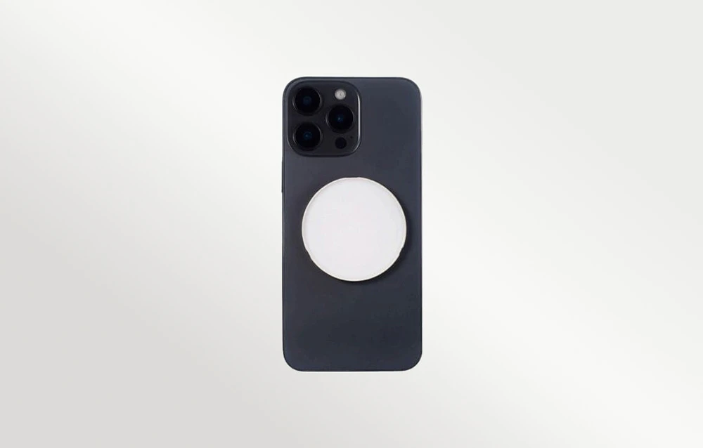 O lampă LED Godox albă, magnetică, atașată pe partea din spate a unui smartphone negru, privită direct din spate