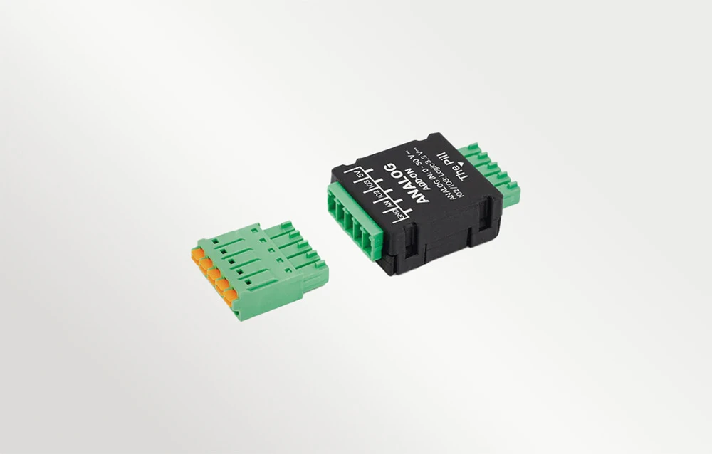 O carcasă neagră și un conector verde separat cu șuruburi pe un fundal alb, cu text vizibil pe carcasă