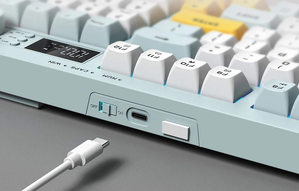 Extras de tastatură cu port USB-C și cablu alb pe fundal gri
