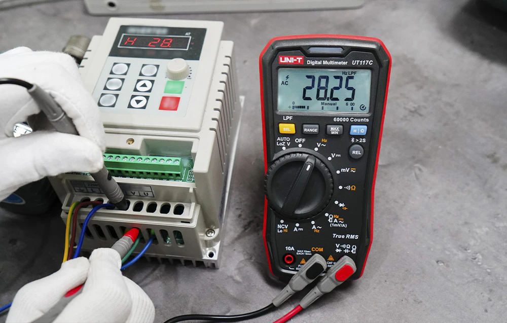 Măsurarea parametrilor electrici folosind un multimetru digital conectat la un invertor industrial.