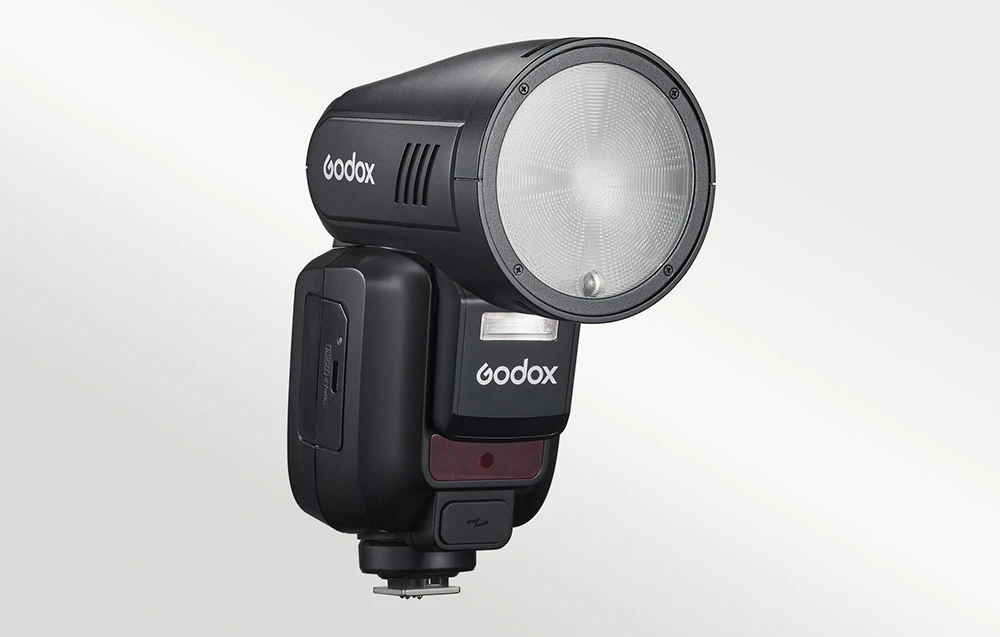 Blițul Godox V100C cu cap rotund, văzut din profil.