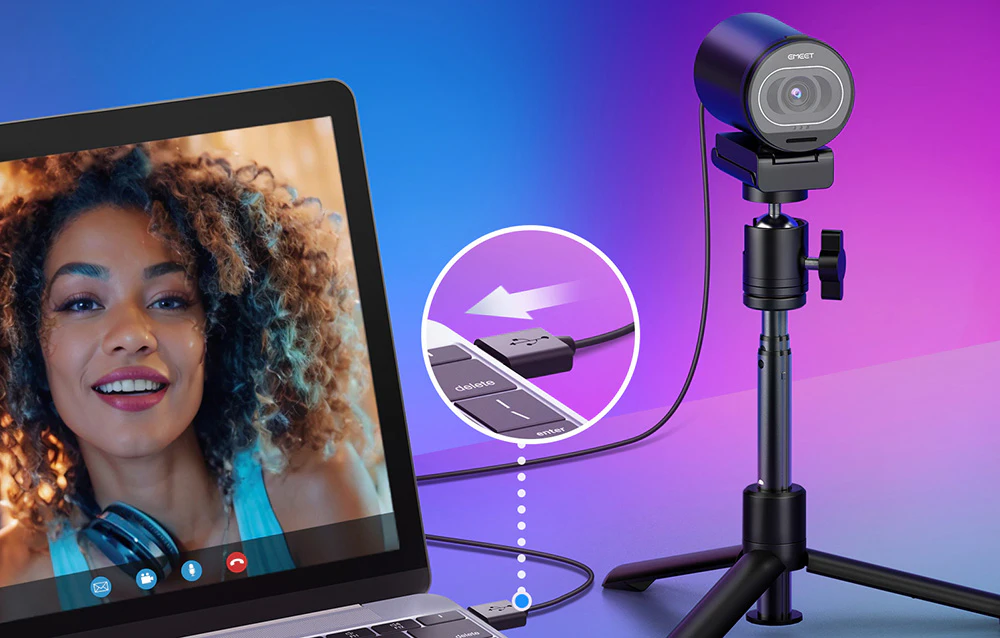 Camera web de pe trepied este conectată printr-un cablu USB la un laptop, pe ecranul căruia are loc o convorbire video cu o femeie