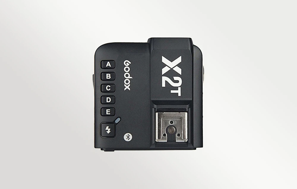 Vedere de sus a transmițătorului radio Godox X2T negru, cu butoanele de grup vizibile și patina de montare