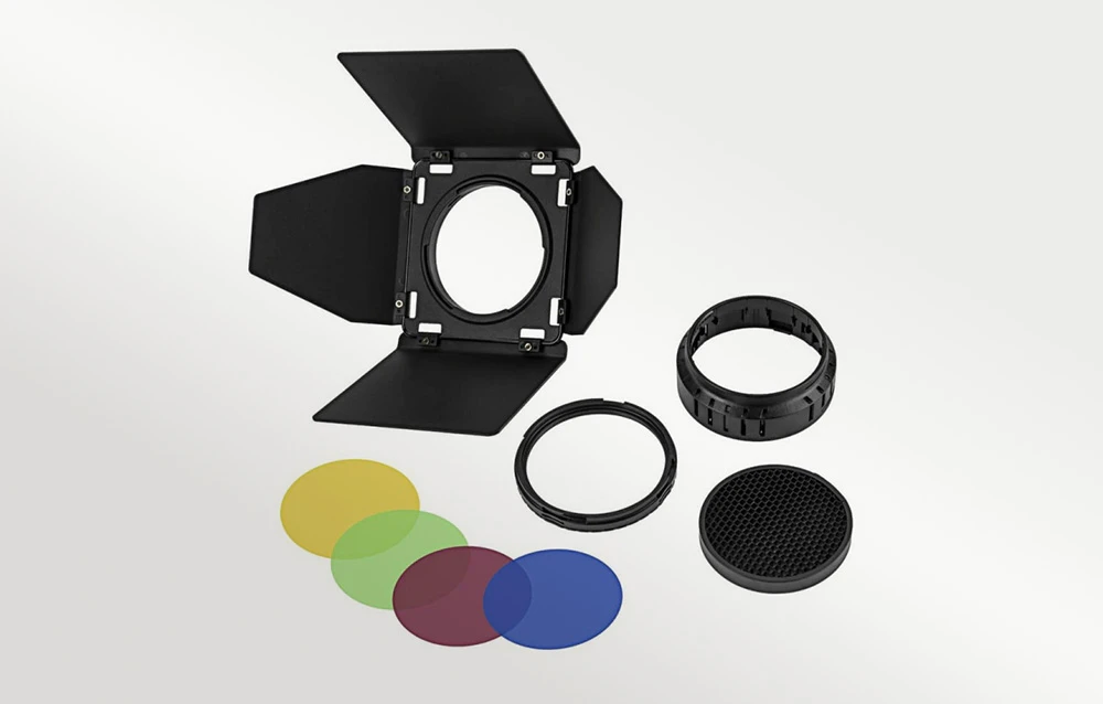Obturatoare negre de studio deschise, patru filtre de culoare, două inele și un accesoriu circular în formă de fagure pe un fundal deschis.