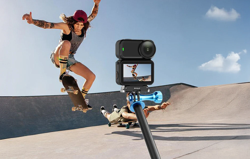 Camera de acțiune montată pe un selfie stick cu suport magnetic albastru PULUZ înregistrează un skateboarder care execută un truc pe un skatepark