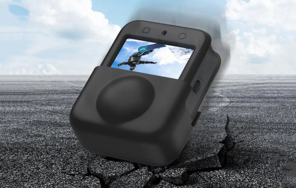 Cameră de 360 de grade în husă de protecție neagră cu imaginea unui snowboarder pe ecran, pe asfalt crăpat