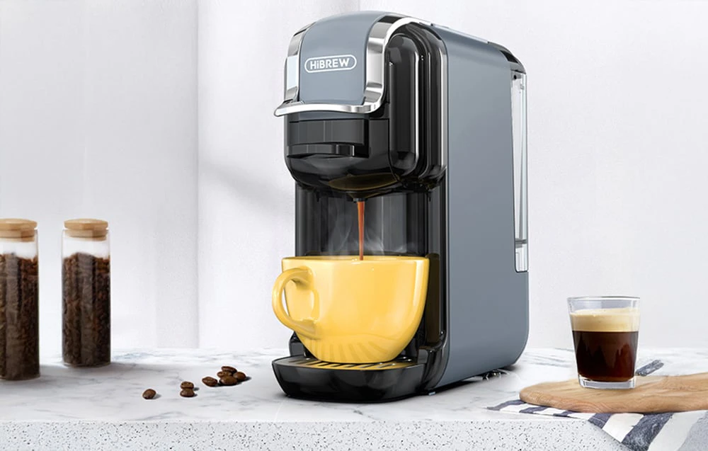 Mașină de cafea cu capsule HiBREW H2B de culoare gri, care prepară cafea într-o ceașcă galbenă.