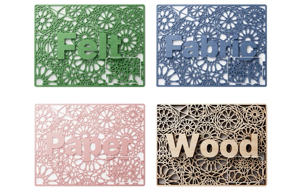 Patru plăci colorate cu modele ajurate și cuvintele „Felt”, „Fabric”, „Paper” și „Wood” decupate de plotterul laser xTool