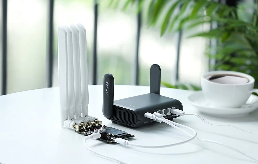Un router negru așezat pe o masă albă lângă o ceașcă de cafea