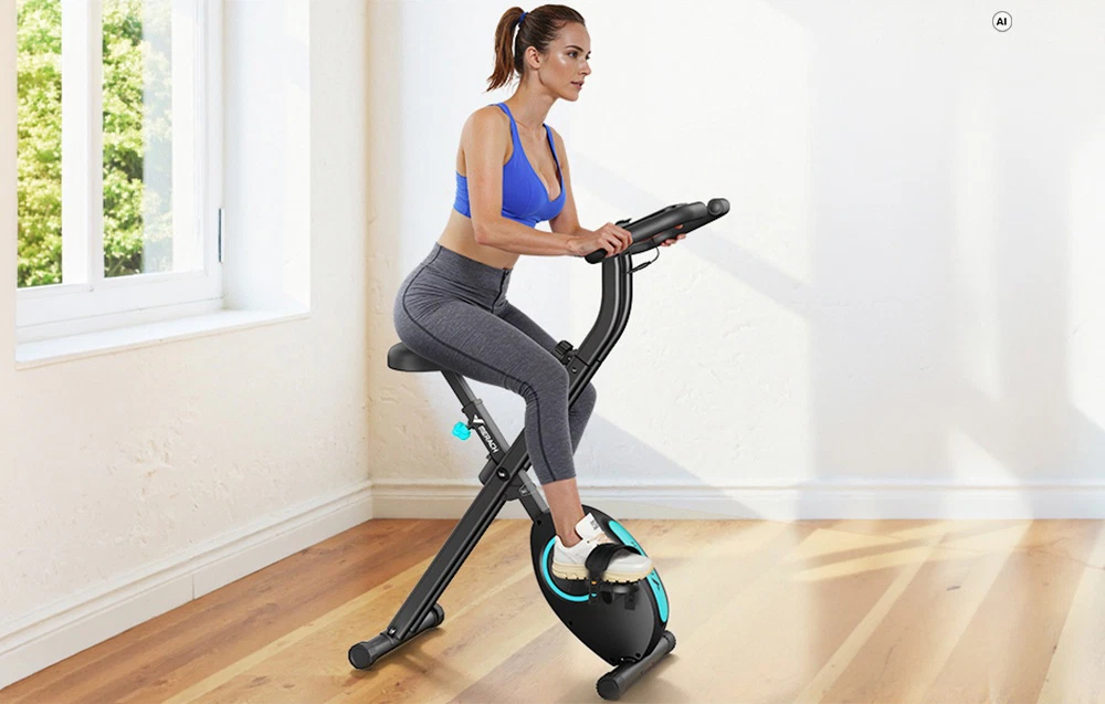 O femeie face exerciții pe o bicicletă de exerciții Merach neagră într-o cameră bine luminată