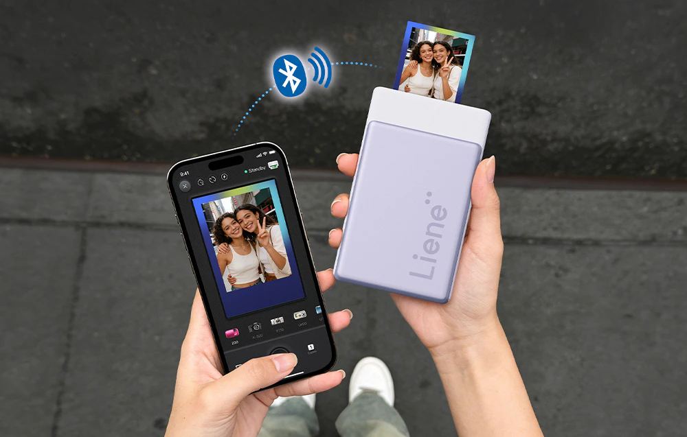 O femeie ținând un smartphone și o imprimantă wireless Liene, din care iese o fotografie mică trimisă prin Bluetooth
