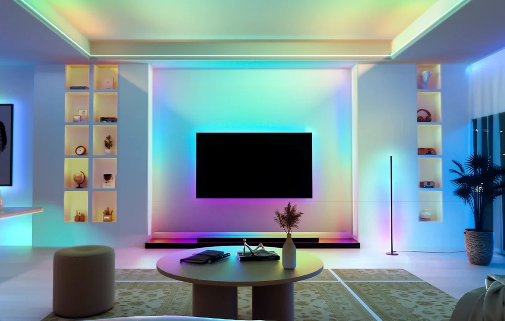 Un living spațios cu un televizor pe perete, iluminat de multiple fluxuri de lumină colorate.