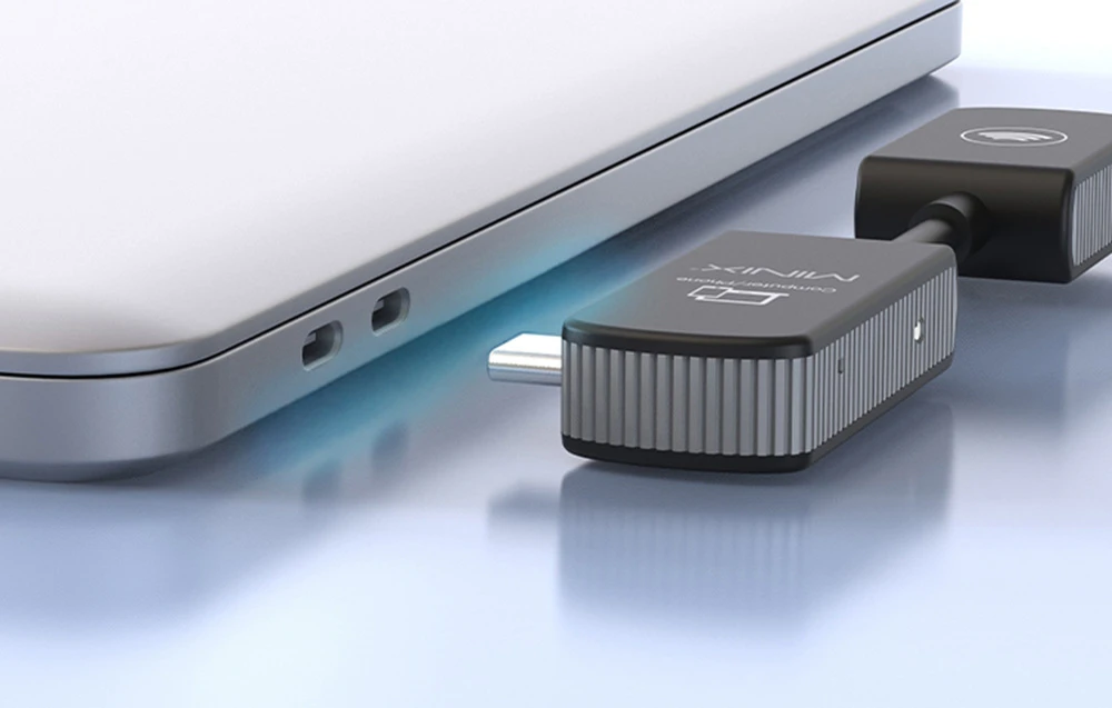 Prim-plan al mufei USB-C a adaptorului MINIX Computer/Phone lângă porturile laterale ale laptopului