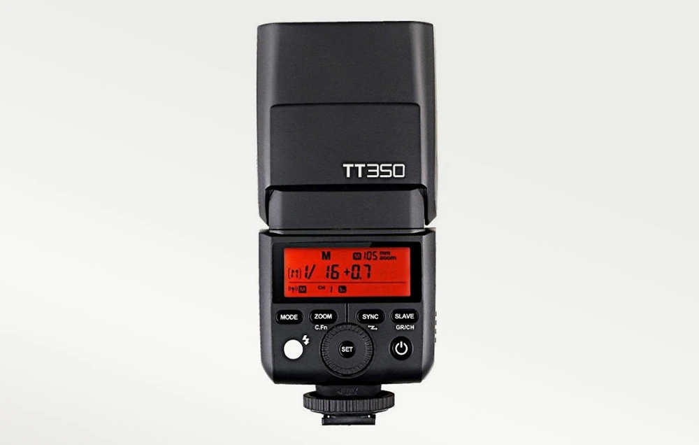Blițul Godox TT350 văzut din spate, cu lumina de fundal portocalie a ecranului LCD aprinsă și panoul de control vizibil