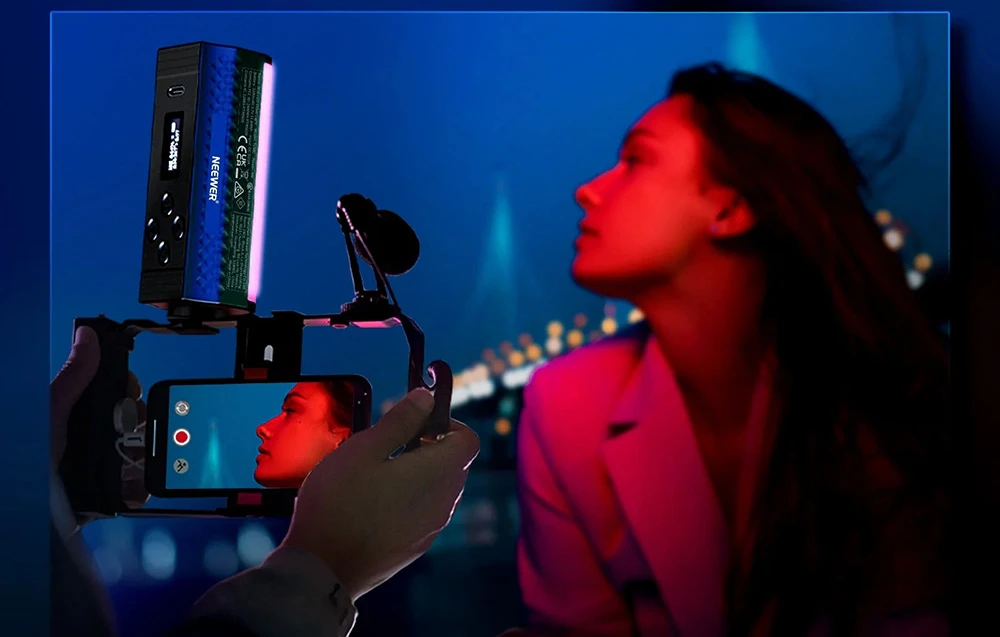 O lampă alungită montată pe un suport pentru smartphone, care iluminează fața unei femei în roșu.