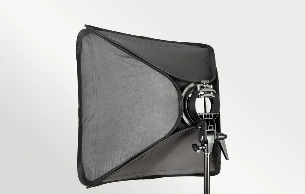 Vedere laterală a unui softbox dreptunghiular montat pe un trepied fotografic cu un suport de fixare.
