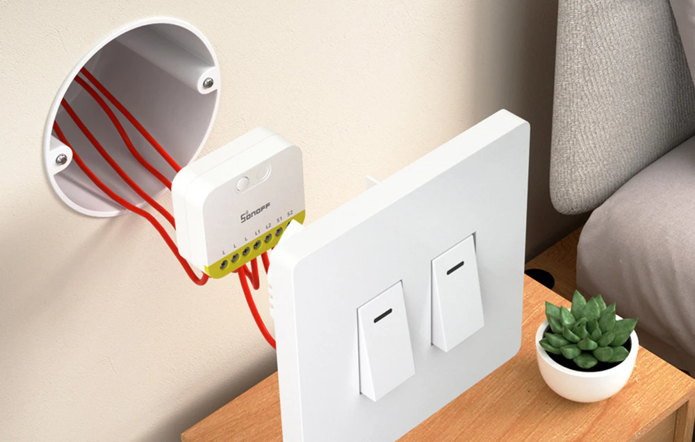 Comutator Sonoff mini instalat într-o cutie de joncțiune în spatele unui comutator de lumină