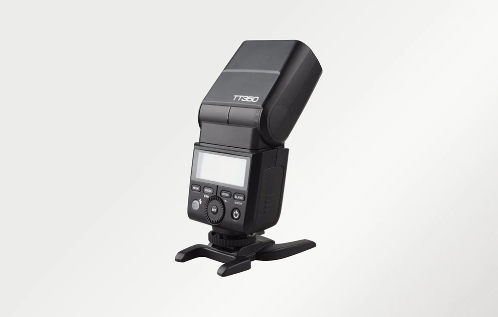 Blițul Godox TT350 pe un stativ din plastic, vedere laterală din spate, capul orientat ușor în sus