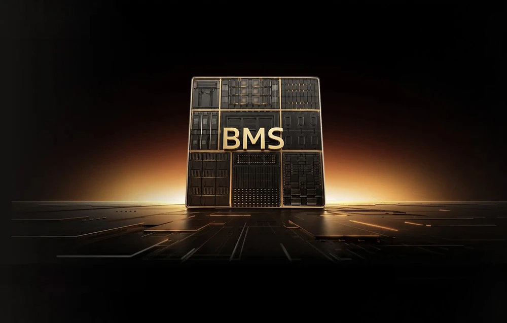 Inscripția aurie „BMS” pe o componentă de culoare închisă, asemănătoare unui circuit integrat, pe un fundal negru cu o strălucire slabă