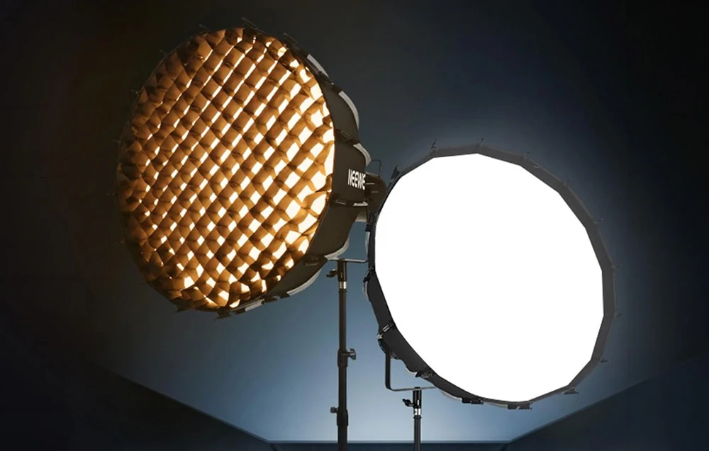 Două softboxuri pe stative: unul cu o grilă tip fagure vizibilă, celălalt cu un difuzor alb de difuzare a luminii.