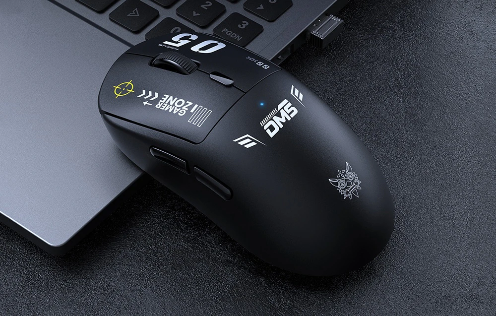 Mouse de computer negru așezat pe un laptop gri