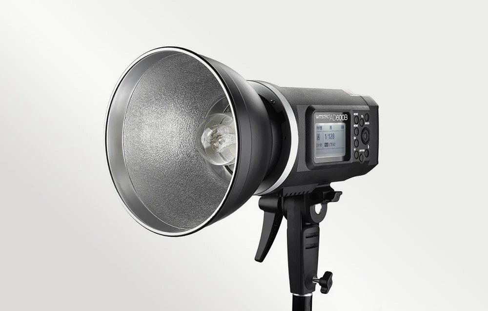 Blițul Godox Witstro AD600B cu reflector metalic și cap de bliț expus, montat pe un stativ de iluminat