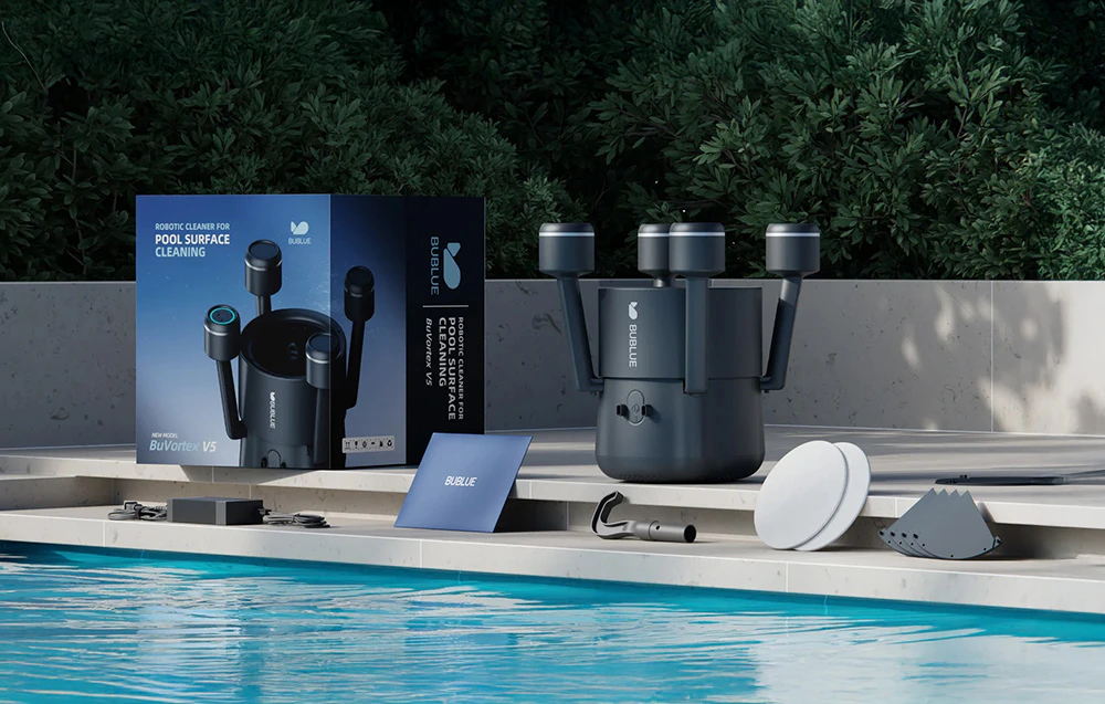 Robotul BuVortex V5 pe marginea piscinei, împreună cu ambalajul său și un set complet de accesorii