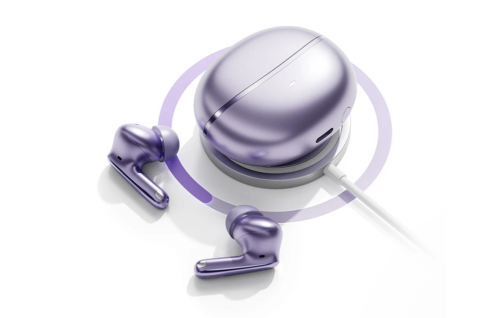 Căști fără fir violet și carcasă de încărcare plasate pe un încărcător fără fir rotund