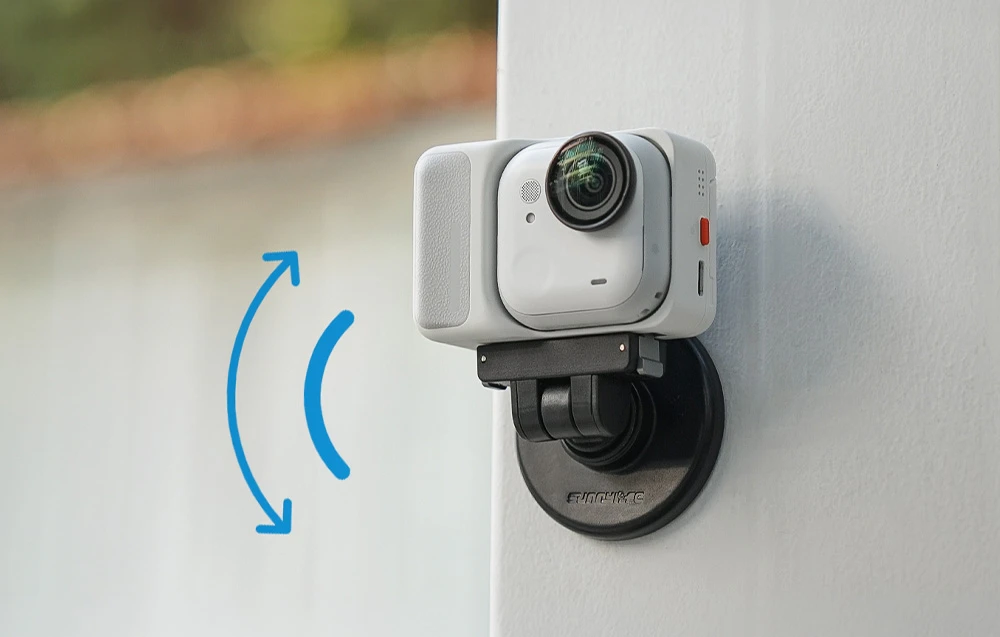Cameră Insta360 GO 3 albă montată magnetic pe un stativ alb, cu o săgeată albastră de mișcare în fundal.