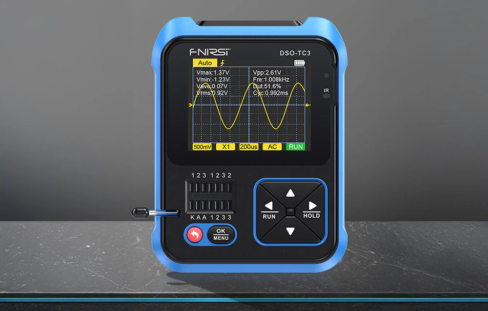 Osciloscopul FNIRSI afișează măsurătorile formei de undă cu parametrii Vmax, Vmin, Vpp și frecvență pe o masă elegantă.