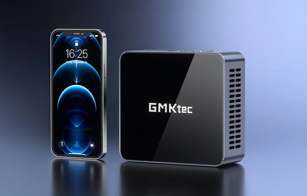 Mini PC GMKtec în picioare lângă un smartphone, arătând dimensiunea aproximativă a dispozitivelor
