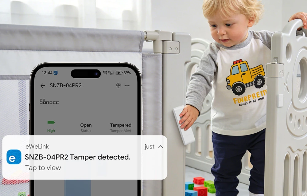 Un copil care se cațără din pătuț, lângă un smartphone pe care apare o notificare