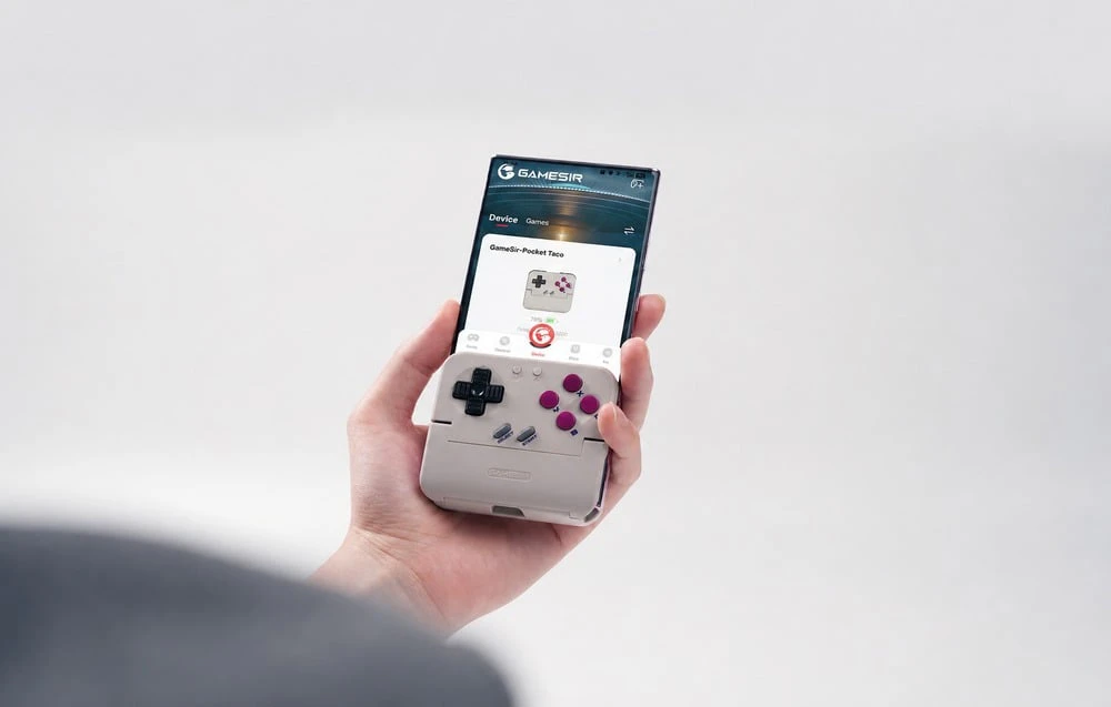 O mână ține un smartphone cu controlerul atașat și aplicația GameSir deschisă