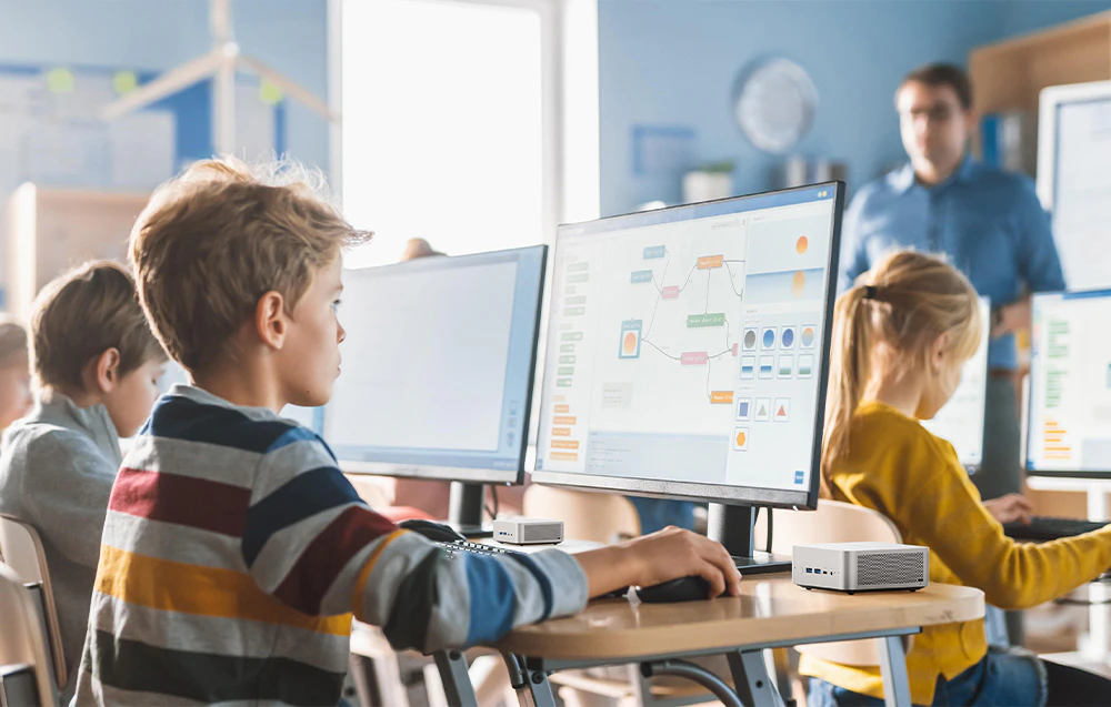 Copiii din sala de clasă efectuează sarcini pe computer, mini pc plasat pe mese