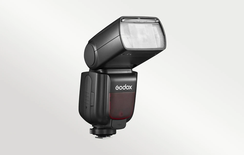 Blițul Godox TT685II văzut din profil, cu capul ridicat și rotit spre dreapta