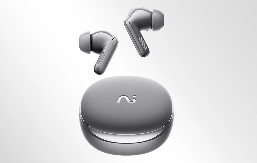 Căști wireless argintii plutind deasupra unei carcase de încărcare închise, pe un fundal de culoare deschisă.