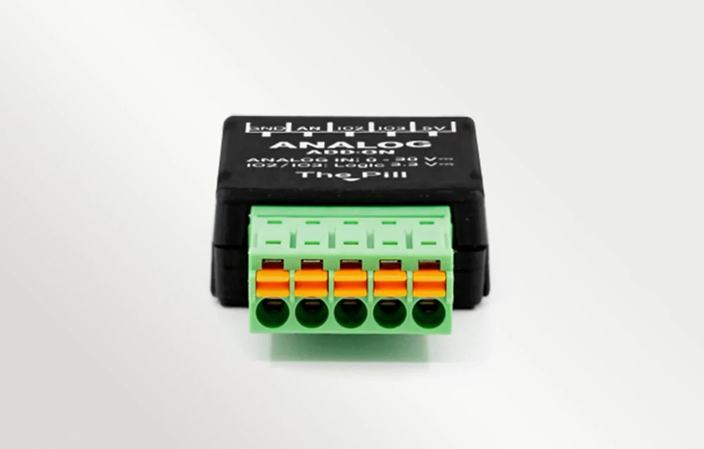 Un conector cu șuruburi pe o suprafață albă, cu text vizibil pe carcasa neagră de lângă acesta